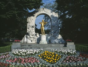 AUSTRIA, Vienna, City Park. Johan Strauss statue with flower beds in the foreground
