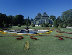 AUSTRIA, Vienna, Schonbrunn Palace formal gardens with fountain and the Palm House