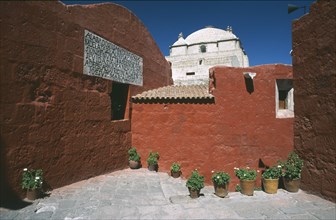 PERU, Arequipa, Alleyway with brightly coloured buildings and the white roof of the Monasterio de