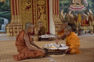 LAOS, Vientiane, Buddhist monks eating meal in Wat Chan.