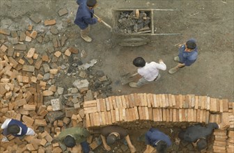 CHINA, Sichuan, Chengdu, Construction site.  Looking down on workers stacking bricks and moving