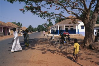 GUINEA BISSAU, San Domingos, Street scene with people and roadside vendor in town in the Casheu