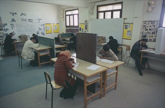 LIBYA, Benghazi, Students sitting an English exam. All male and one female.