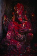 NEPAL, Kathmandu, Godavari, Statue of Ganesh covered in red powder on the side of the Godavari
