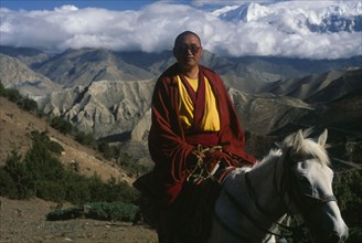 NEPAL, Mustang, Lobsang , High ranking Tibetan lama riding over high mountain pass.