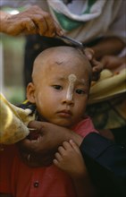 MYANMAR, Children, Ritual head shaving of initiate monk.