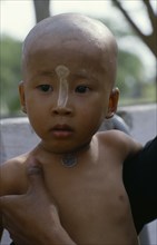 MYANMAR, Children, Initiate monk after ritual head shaving.