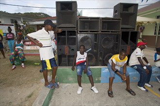 WEST INDIES, St Vincent & The Grenadines, Union Island, Young men sitting beneath a sound system at