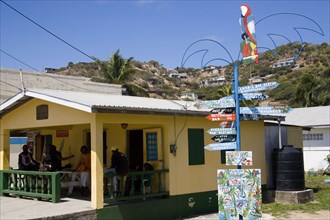 WEST INDIES, St Vincent & The Grenadines, Union Island, Signpost beside a rum shop in Clifton