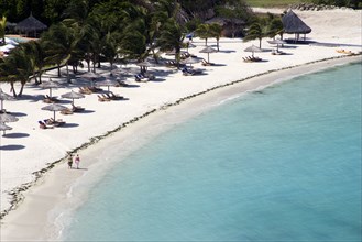 WEST INDIES, St Vincent & The Grenadines, Canouan, Two women walking along Jambu Beach at Raffles