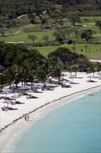 WEST INDIES, St Vincent & The Grenadines, Canouan, Two women walking along Jambu Beach at Raffles