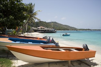 WEST INDIES, St Vincent & The Grenadines, Mustique, Fishing boats on beach in Britannia Bay with