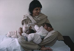 PAKISTAN, People, Pakistani woman breastfeeding her twins aged three months.