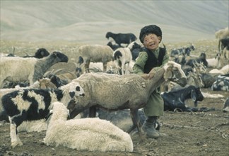 AFGHANISTAN, General, Nomadic Kirghiz child with sheep and goat herd.