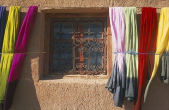 MOROCCO, Ait Benhaddou, Detail of window with decorative metal screen set into wall with colourful