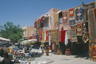 MOROCCO, Marrakesh, "The souk with carpets displayed from walls and awnings of shopfronts opposite