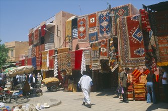 MOROCCO, Marrakesh, The souk with carpets displayed from walls and awnings of shopfronts opposite