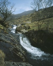 WALES, Snowdonia, Cwm y Llan Waterfall, Waterfall cascading over rocks in stream flowing south east