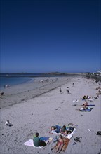 UNITED KINGDOM, Channel Islands, Guernsey, Castel. Cobo Bay. Sandy beach with sunbathers