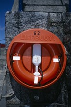 UNITED KINGDOM, Channel Islands, Guernsey, St Peter Port. Red Lifebuoy attached to sea wall.