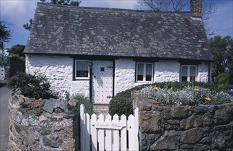 UNITED KINGDOM, Channel Islands, Guernsey, St Saviours. Small white cottage on corner of road
