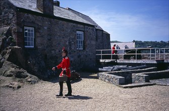 UNITED KINGDOM, Channel Islands, Guernsey, St Peter Port. Castle Cornet. Noon Day Guard walking in