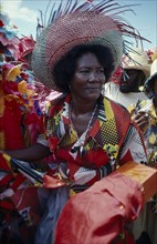 HAITI, People, Three-quarter portrait of woman at a Ra Ra procession wearing wide brimmed straw hat