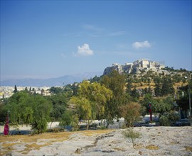 GREECE, Central, Athens, A road with trees either side in the foreground with the Acropolis up the