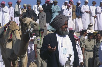 OMAN, Central , "Omani sheikh with prize camel at the end of 50km race, receiving prize."