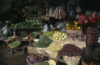 SRI LANKA, Kandy, "Vendors and open fronted stall with display of flowers, vegetables and spices."