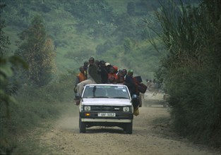 UGANDA, Transport, Car with people overloaded on the back.