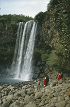 SOUTH KOREA, Cheju Island, Honeymoon Falls, Couples in traditional dress at rocky foot of waterfall