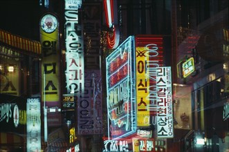 SOUTH KOREA, Songtansi, Neon shop signs illuminated at night.