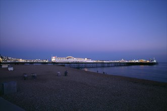 ENGLAND, East Sussex, Brighton, Brighton Pier illuminated in evening light.