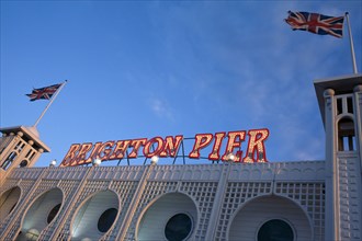ENGLAND, East Sussex, Brighton, Brighton Pier. Detail of neon sign with Union Jack flags flying