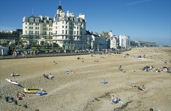 ENGLAND, East Sussex, Eastbourne, Busy shingle beach and beachfront buildings.