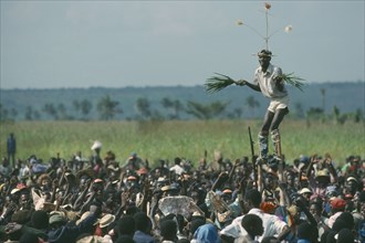 CONGO, Gungu, Stilt walker above crowds at Bapende tribe Gungu Festival.