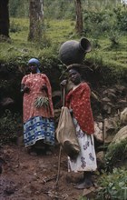 RWANDA, Farming, Female agricultural workers with one woman carrying large pot on her head.