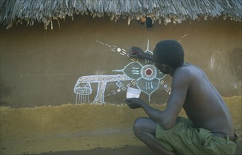 KENYA, Kakuma, Dinka man decorating house in refugee camp.