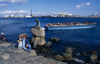 DENMARK, Zealand, Copenhagen, Family posing for photograph beside the Little Mermaid statue with