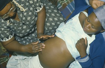 BOTSWANA, Pregnancy, Traditional midwife massaging patient.