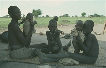 SUDAN, Children, Twins, Dinka mother with twin babies and two older children.