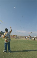THAILAND, Bangkok, "Kite festival at Sanam Luang, February. Boy flying one in foreground, many