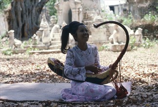 MYANMAR, Amarapura, Female musician playing Burmese harp.