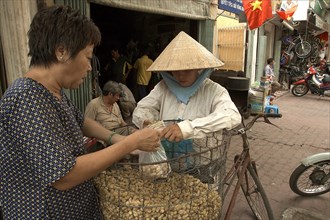 VIETNAM, South, Ho Chi Minh City, A woman selling peanuts from her bicycle