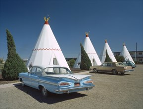 USA, Arizona, Holbrook, The Wigwam Motel made from stone with vintage cars parked outside