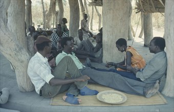SUDAN, People, Dinka people gathered for story telling in village meeting house.