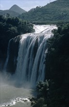 CHINA, Guizhou Province, Huangguoshu Falls, Waterfall cascading from vegetation covered karst