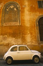 ITALY, Tuscany, Florence, White Fiat 50 parked outside old building with faded ochre coloured