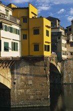 ITALY, Tuscany, Florence, Ponte Vecchio.  Buildings on bridge above the River Arno with people